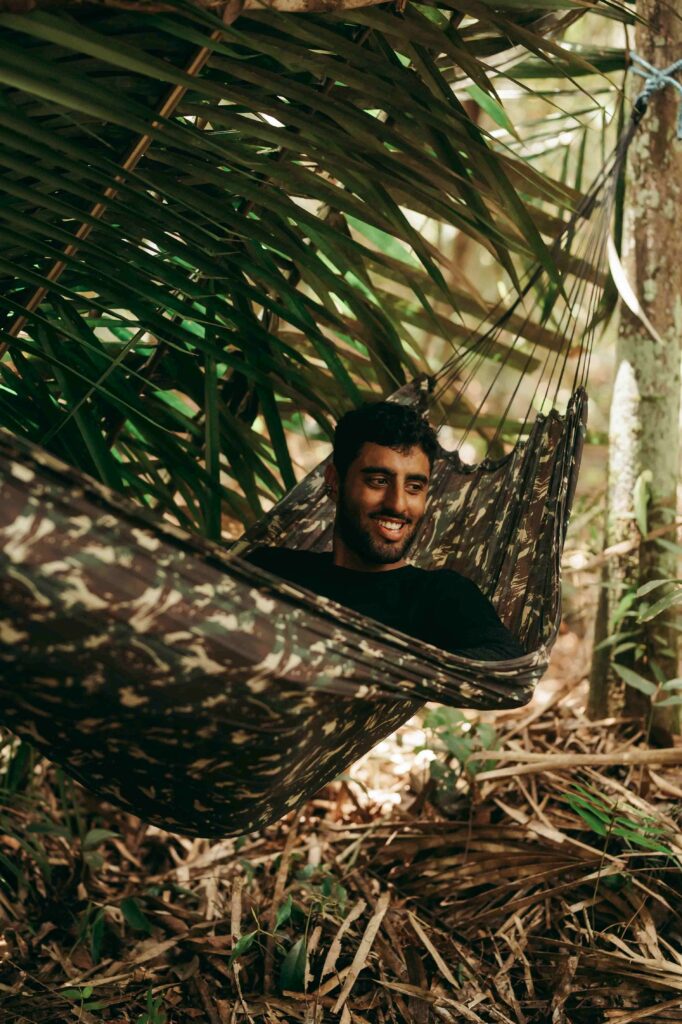 um homem deitado na rede no meio da selva amazônia em uma experiência de jungle survival - um roteiro soft adventure do Amazon Camp Lodge